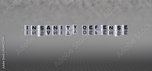 insanity defense word or concept represented by black and white letter cubes on a grey horizon background stretching to infinity photo