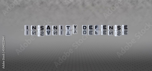 insanity defense word or concept represented by black and white letter cubes on a grey horizon background stretching to infinity