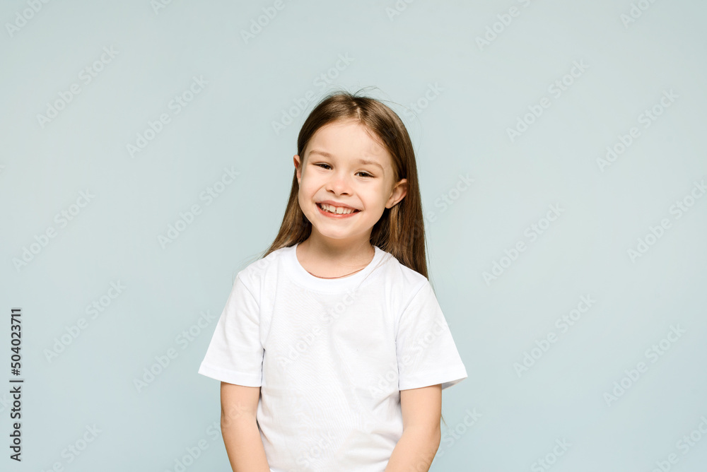 Happy little girl on blue background with copy space. Happy little girl on blue background with copy space.
