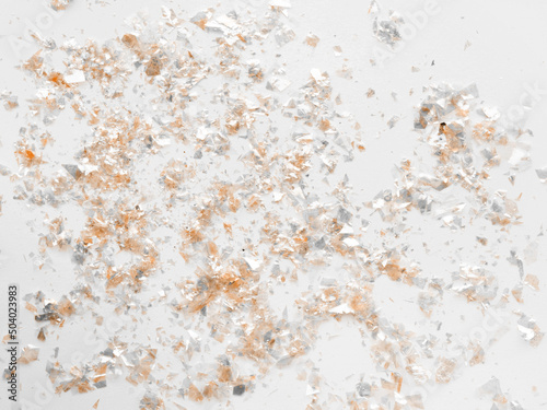 Gold and Silver Metallic Confetti on a White Background.Simple Modern Composition with Golden Shimmering Confetti Scattered Confetti ideal for Banner, Card. Top-Down View. No text. Party Layout. © Magdalena