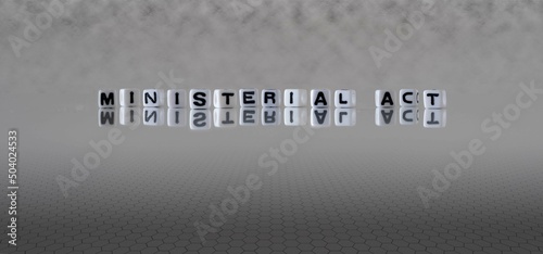 ministerial act word or concept represented by black and white letter cubes on a grey horizon background stretching to infinity