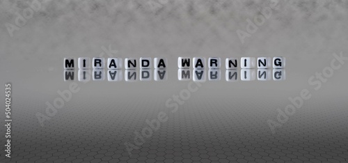 miranda warning word or concept represented by black and white letter cubes on a grey horizon background stretching to infinity