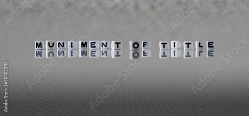 muniment of title word or concept represented by black and white letter cubes on a grey horizon background stretching to infinity photo