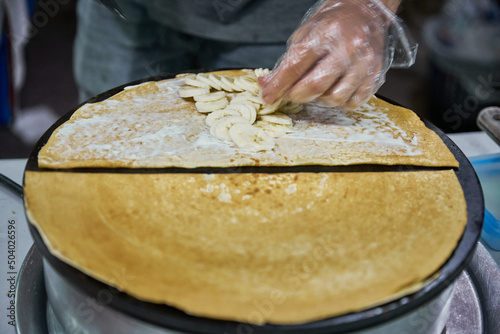 Making delicious crepes on a grill with fruit and chocolate