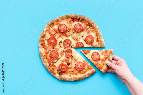 Taking a slice of pizza. Homemade vegetarian pizza above view