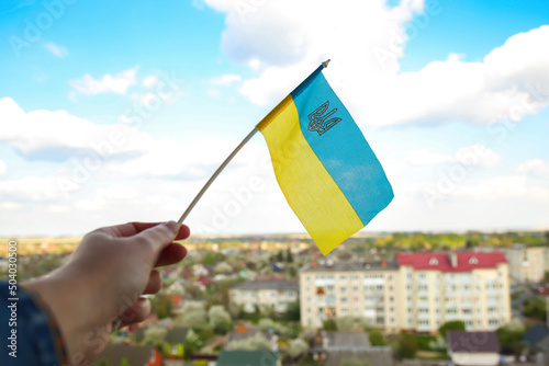 Defocus Ukraine flag. Large national symbol fluttering in blue sky. Support and help Ukraine, Independence Constitution Day, National holiday. Hand holding flag. War. Out of focus