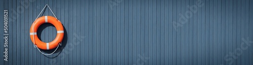 An orange lifebuoy hangs from a white cord on a grey blue wooden background. The concept of safety of people on the water, river, sea, ocean. Decorative nautical style
