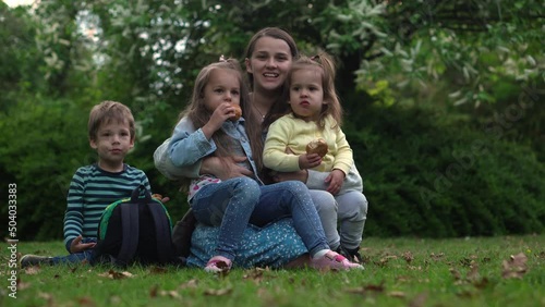 Happy family mom Three little siblings kids have fun blowing bubbles enjoying summer holidays in garden park. Smiling parents children spending leisure time together evening sunset Motherhod Mother photo