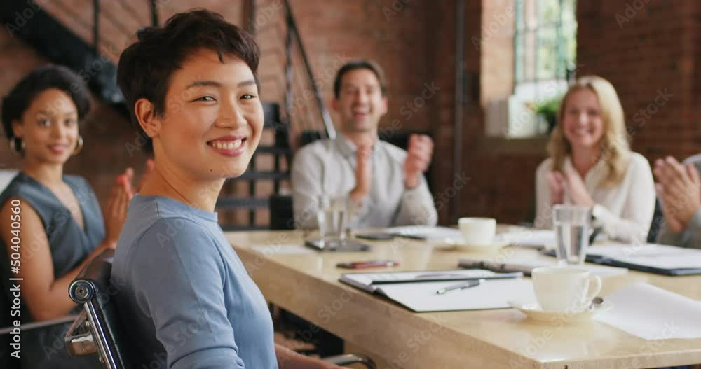 a young businesswoman having a meeting with her colleagues in a modern office. Happy young asian businesswoman sitting in a boardroom during a meeting with her coworkers clapping and celebrating. a young businesswoman having a meeting with her colleagues in a modern office. Happy young asian businesswoman sitting in a boardroom during a meeting with her coworkers clapping and celebrating.