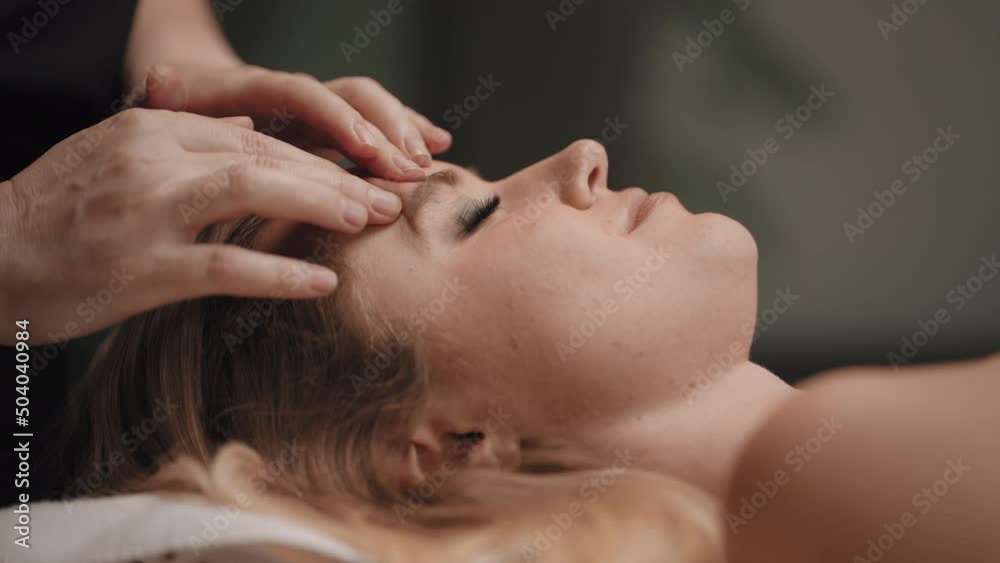 chiropractor is massaging acupuncture points on face of woman for relaxing and curing headache chiropractor is massaging acupuncture points on face of woman for relaxing and curing headache