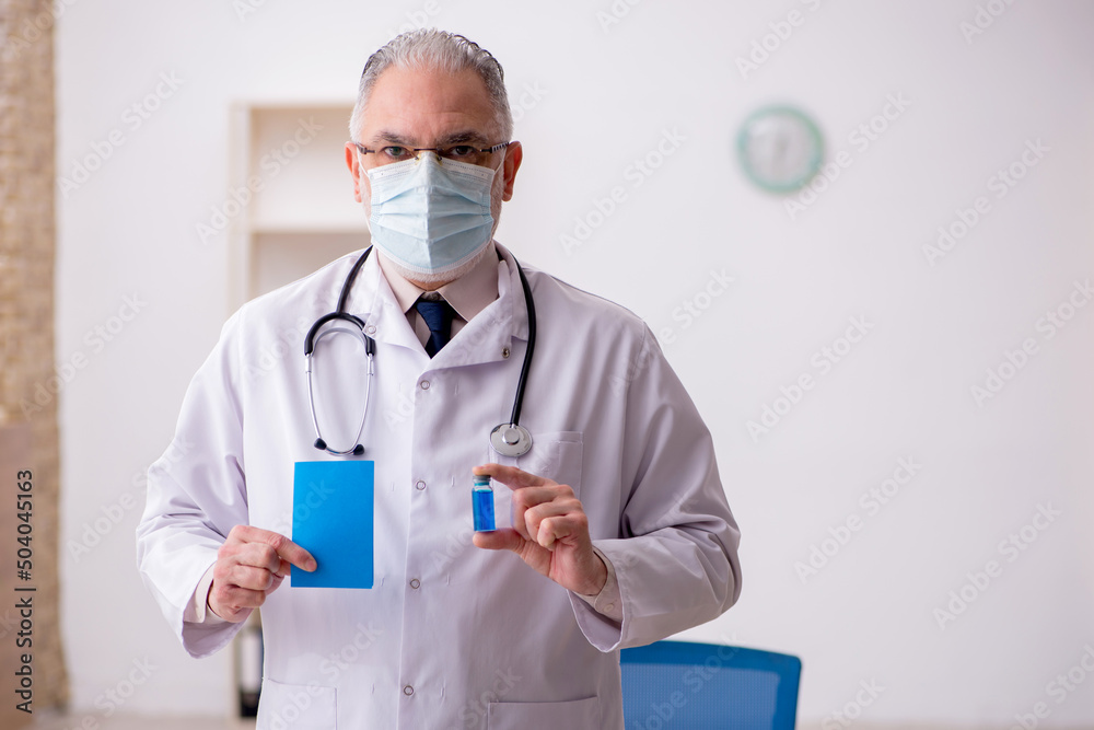 Fototapeta premium Old male doctor in vaccination concept