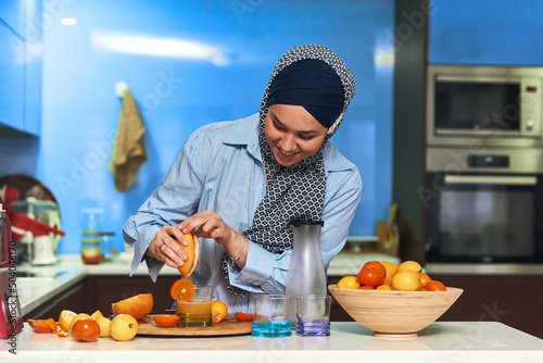  Arab hijab woman making fruit juice in modern kitchen. Home concept. Healthy lifestyle concept. Selective focus . High quality photo
