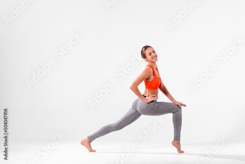 A girl in sportswear makes painful stretching. Horizontal photo of sports on a billboard