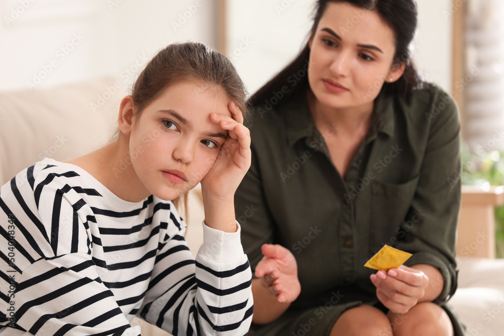 Mother talking with her teenage daughter about contraception at home. Sex education concept Mother talking with her teenage daughter about contraception at home. Sex education concept