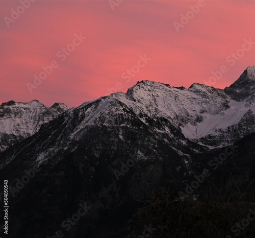 Purple and pink sunset over snow capped alpine mountains (Aosta, Italy)