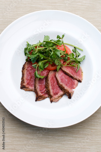 Slices of beef with tomatos and arugula