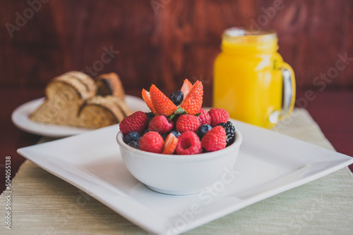 Bowl of fruit with orange juice photo