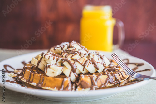 Waffle topped with chocolate and bananas photo