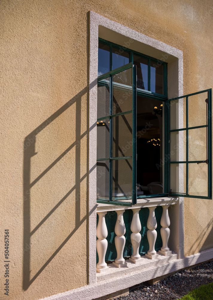 Obraz premium Turquoise Window Frames and Glass with a Shadow on a Yellow and White Building.