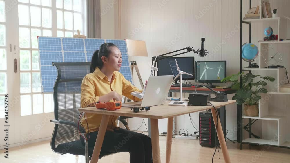 Asian Woman Sitting In Front Of Solar Cell Looks At Wind Turbine While Typing On A Laptop At The Office
Asian Woman Sitting In Front Of Solar Cell Looks At Wind Turbine While Typing On A Laptop At The Office