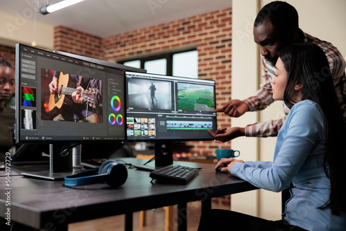 Creative agency video graphic editor expert enhancing footage using visual timeline and advanced software. Asian woman sitting in office workspace working on film project. photo