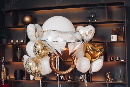 Bridal air balloons against book shelves.