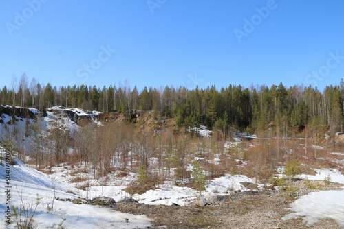 Quarry and rocks in Siberia. Stones, coniferous trees, snow and ice in a quarry in Siberia and the Urals.