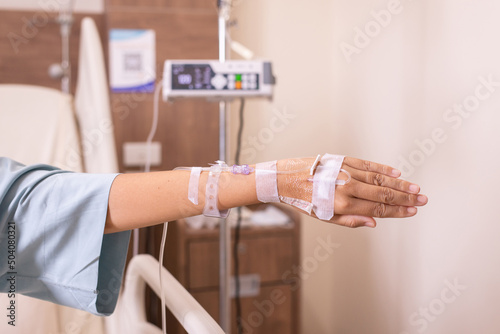 Hand patient women receiving saline solution during sitting on sick bed at hospital