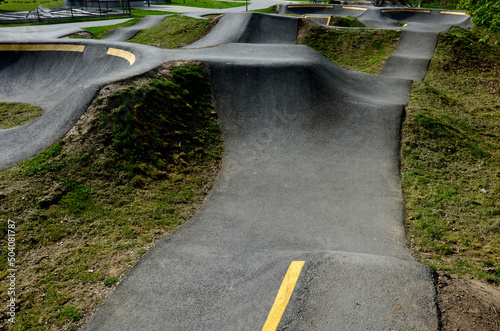 bike path in the car park Pumping (moving up and down) is used instead of pedaling and bouncing to move bicycles, scooters, skateboards and inline skates along the modular pumptrack track photo