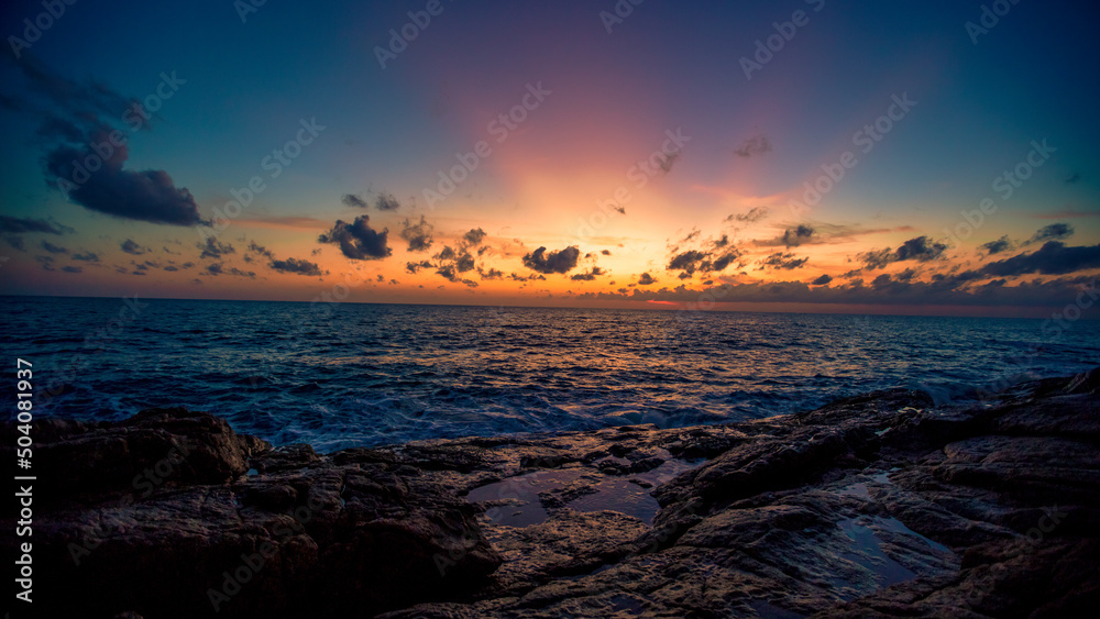 Blurred nature background of the morning sun by the sea, a beautiful golden light, among the trees, rocks and local fishing boats, the beauty of nature during the day. Blurred nature background of the morning sun by the sea, a beautiful golden light, among the trees, rocks and local fishing boats, the beauty of nature during the day.