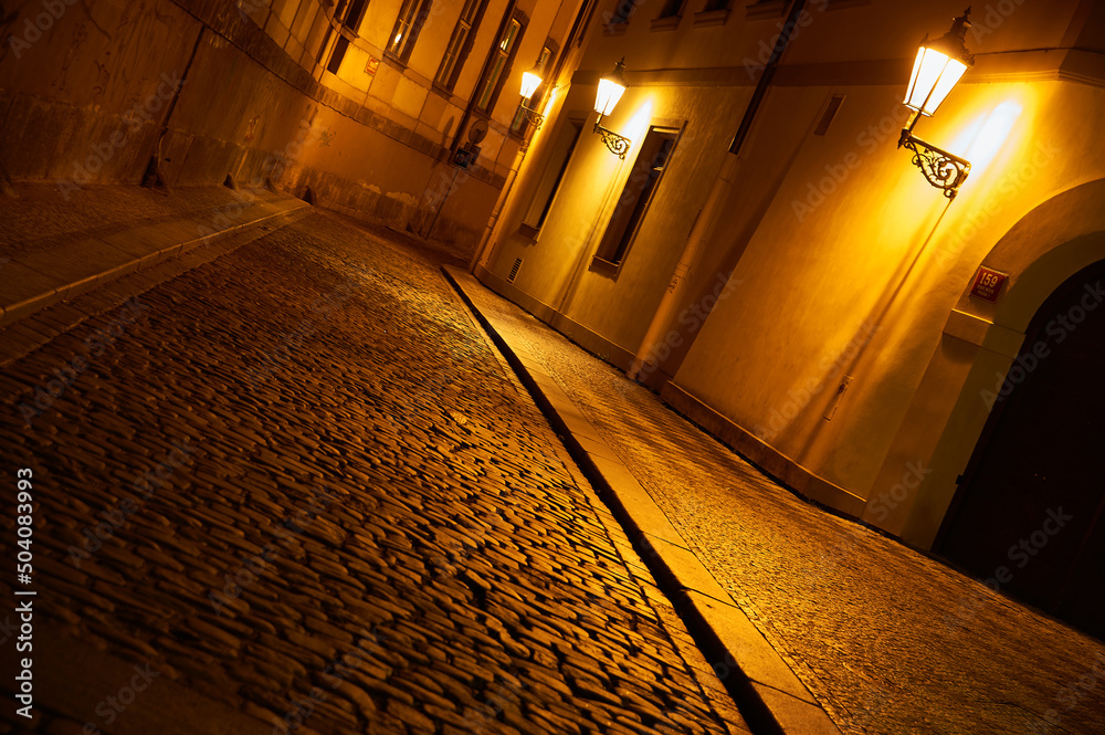 historic street in the old town lit by lanterns in the evening. Prague, Czech Republic