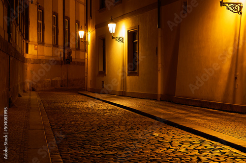 Obraz na płótnie historic street in the old town lit by lanterns in the evening. Prague, Czech Republic w salonie