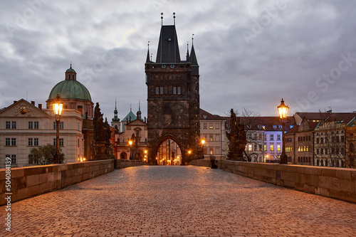 Obraz na płótnie empty charles bridge, lit lateran, at sunrise in prague, czech republic w salonie