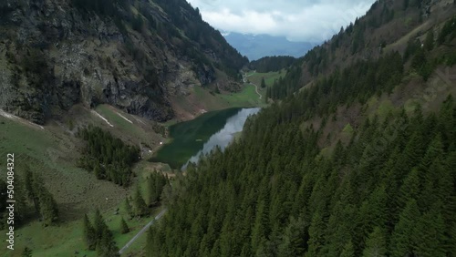 Aerial sideways establish wonderful tiny green mountain lake in the swiss alps