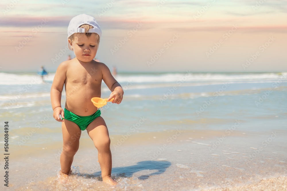 Kid collects shells and pebbles in the sea on a sandy bottom under the summer sun on a vacation Kid collects shells and pebbles in the sea on a sandy bottom under the summer sun on a vacation