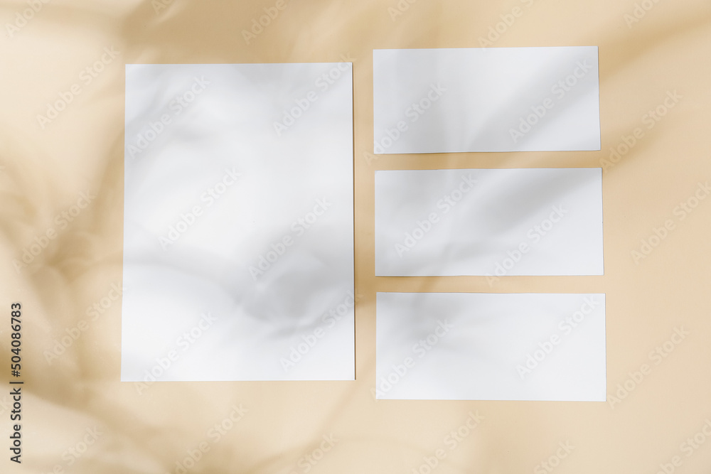 Blank paper sheets and shadows on color background