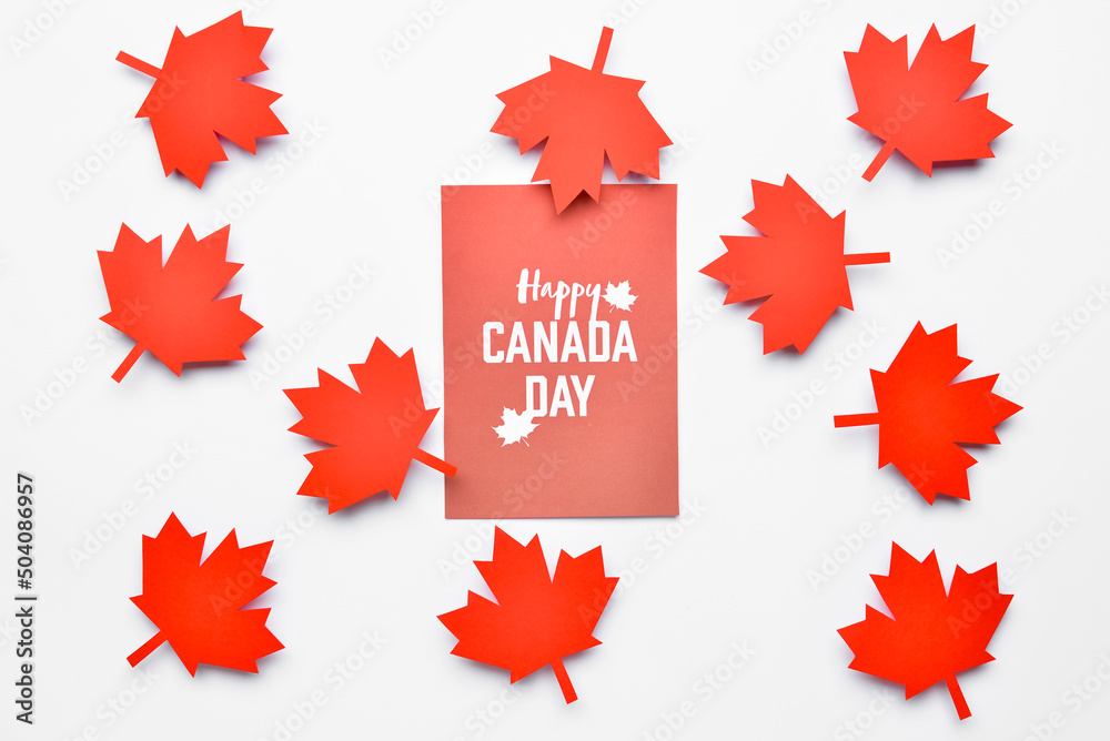 Maple leaves and paper card with text HAPPY CANADA DAY on white background Maple leaves and paper card with text HAPPY CANADA DAY on white background