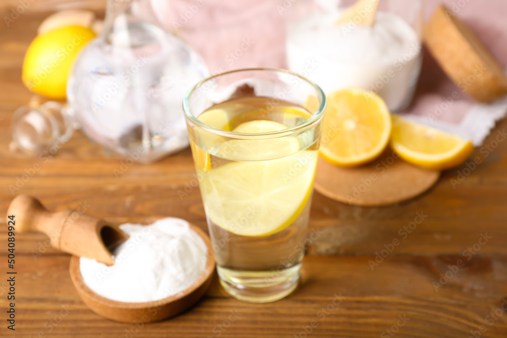 Glass of water and bowl with baking soda on wooden background Glass of water and bowl with baking soda on wooden background