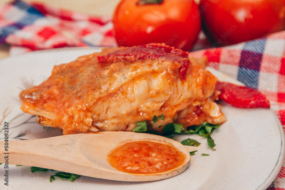 slice of grilled fish with tomato sauce and red peppers