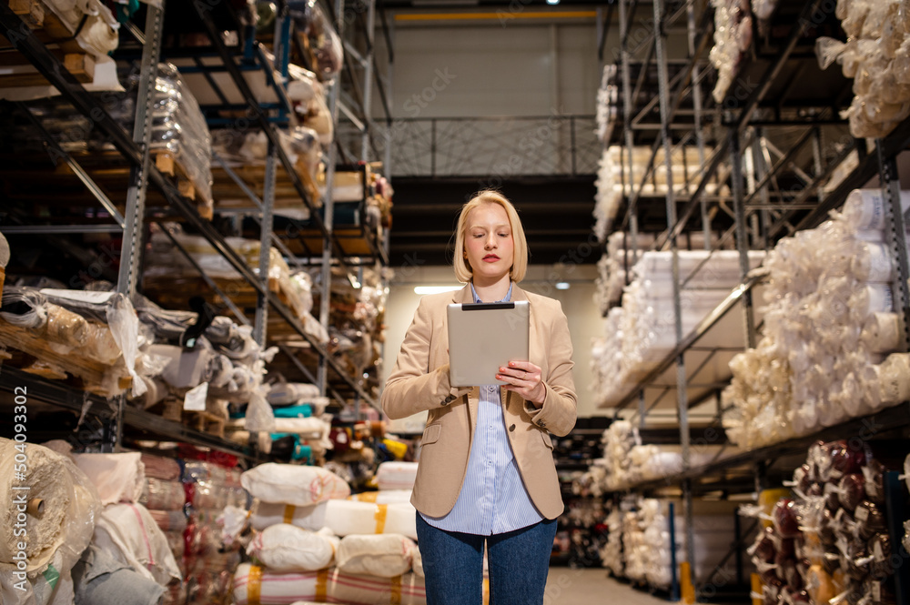 Europe business woman doing inventory at a warehouse using a tablet computer