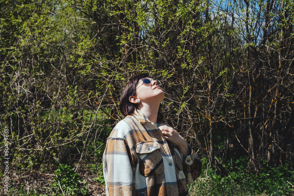 Portrait of a happy, free, peaceful woman in nature looking up. The concept of mental health, self-care and simple pleasures Portrait of a happy, free, peaceful woman in nature looking up. The concept of mental health, self-care and simple pleasures