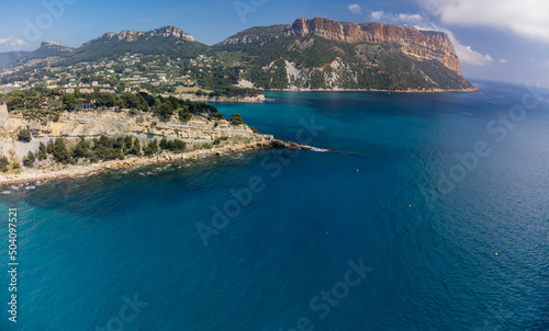 Fototapeta Naklejka Na Ścianę i Meble -  Panoramic aerial view on cliffs, blue sea, beach, houses, streets and old fisherman's harbour with lighthouse in Cassis, Provence, France