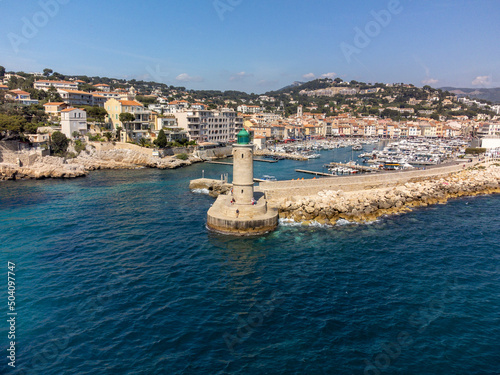 Panoramic aerial view on cliffs, blue sea, beach, houses, streets and old fisherman's harbour with lighthouse in Cassis, Provence, France