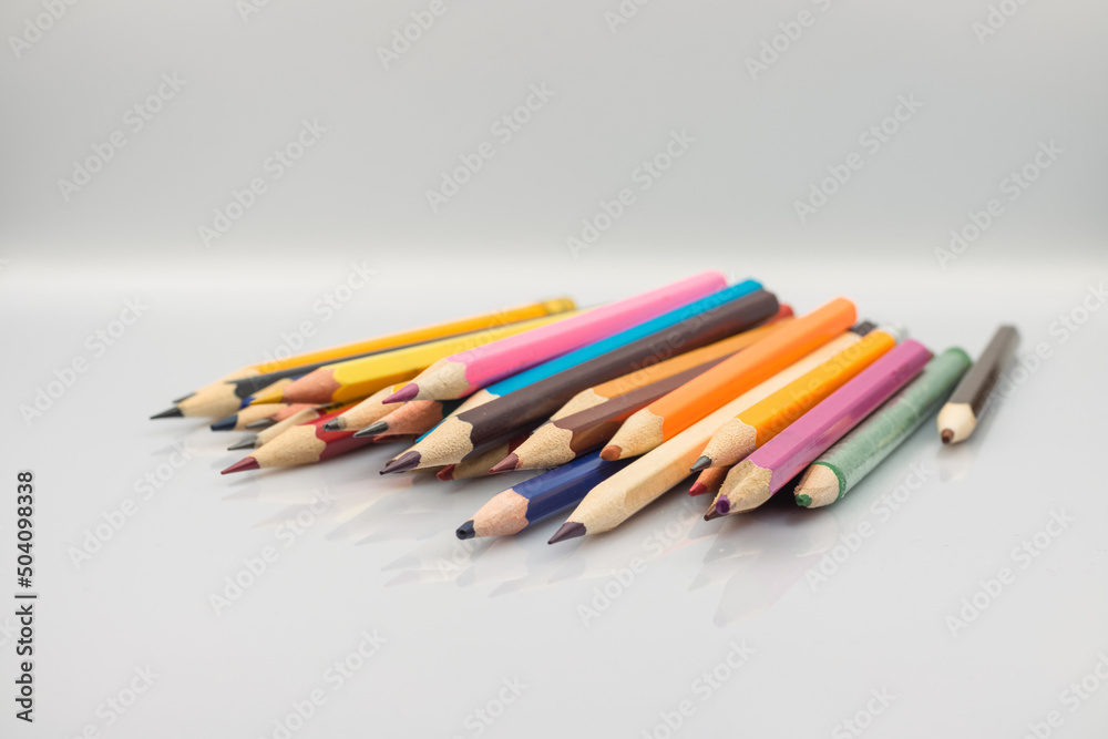a lot of colored pencils on a white table