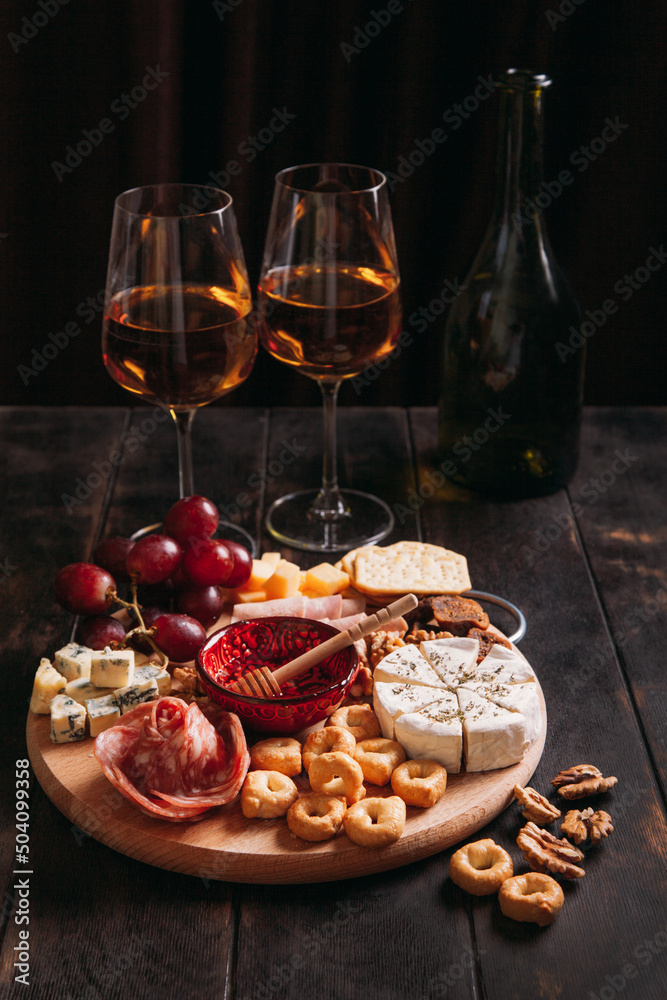 Wine appetizer. Sausage and cheese cut with fruit, cookies and sauce with two glasses of white port and a bottle.