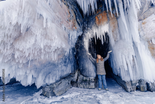 Adventure extreme woman tourist background of frozen grotto and pure ice winter Lake Baikal © Parilov
