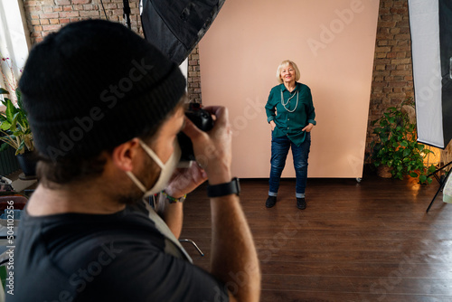 Young photographer taking picures of elderly woman, backstage of photoshooting in studio Fototapet