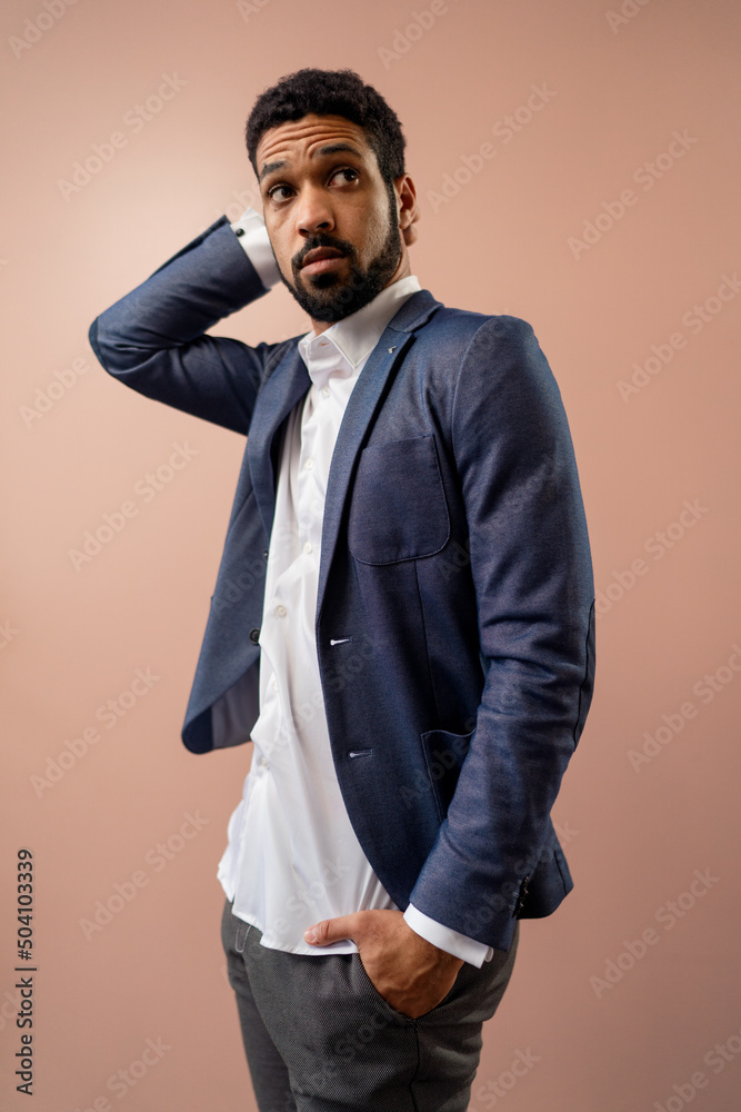 Fototapeta premium Serious young businessman looking at camera, studio shot.