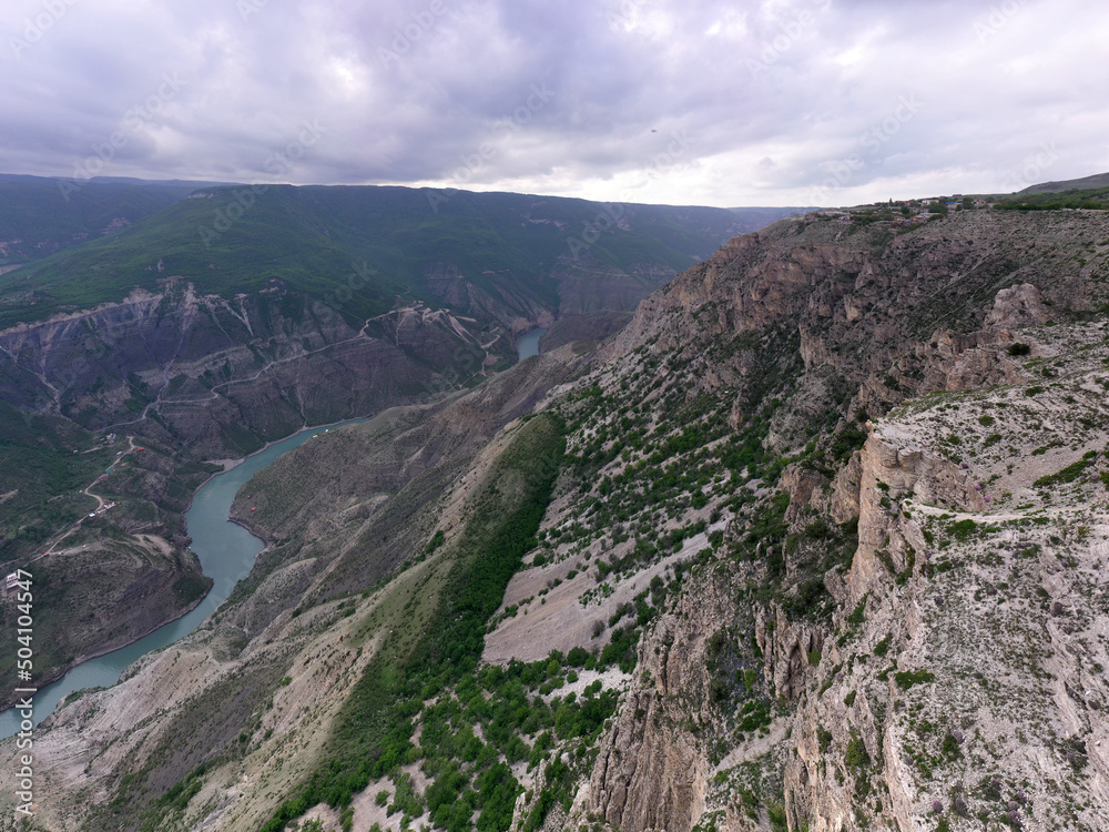 panoramic view of the Caucasus Mountains gorges and curved mountain roads on a spring day