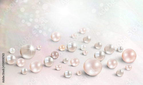 Many shimmering pink and champagne pearls on nacreous mother of pearl background with space for text